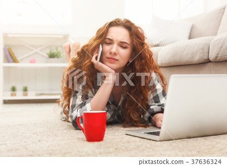 Girl with laptop and mobile lying on the floor 37636324