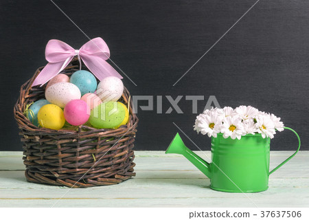 Basket with Easter eggs and a daisy bouquet Basket with Easter eggs and a daisy bouquet 37637506