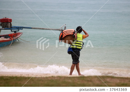 Tourists with raincoat or Life jacket on the beach 37643369
