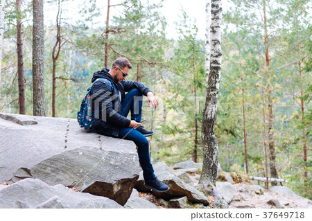 guy sits in the woods on a rock guy sits in the woods on a rock 37649718