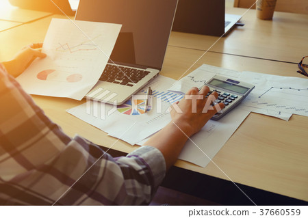 Asian Business woman using a calculator Asian Business woman using a calculator 37660559