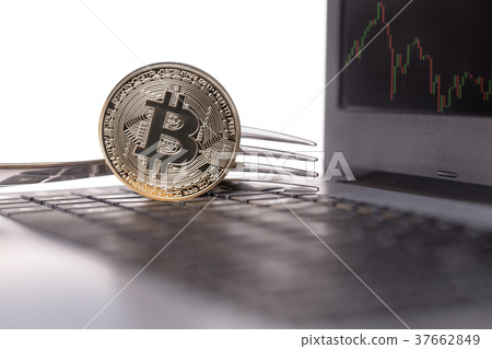 Bitcoin in a fork on a laptop computer. On monitor 37662849