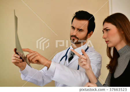 Health Concepts. Doctor and patient viewing x-ray film. The doct Health Concepts. Doctor and patient viewing x-ray film. The doct 37663523