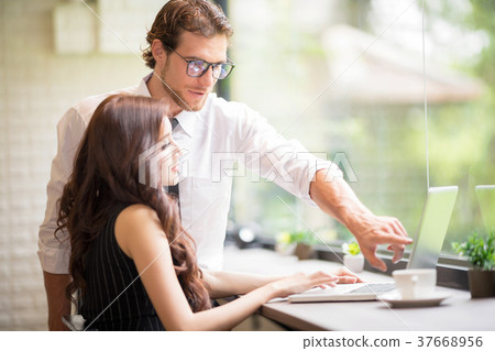 Businessman is helping and teach woman worker. Businessman is helping and teach woman worker. 37668956
