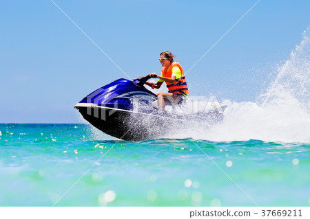 Teenager on jet ski. Teen age boy water skiing. 37669211