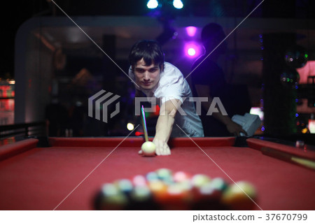 Young handsome man playing in pool at night bar 37670799