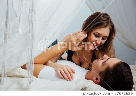 Sexy couple kissing in bed with canopy. Beautiful 37671629