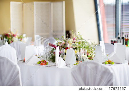 Beautiful table setting with crockery and flowers 37673367