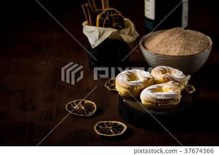 Three sweet cream puffs on dark board Three sweet cream puffs on dark board 37674366