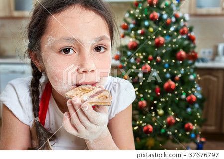 Little girl baking Christmas cookies at home Little girl baking Christmas cookies at home 37676797