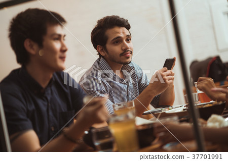 Asian men are using the phone while dining Asian men are using the phone while dining 37701991