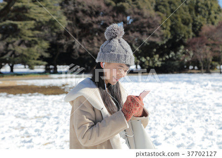 Woman listening to music on smartphone 37702127
