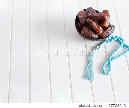 Organic dates Medjool in coconut bowl and rosary. Organic dates Medjool in coconut bowl and rosary. 37702643