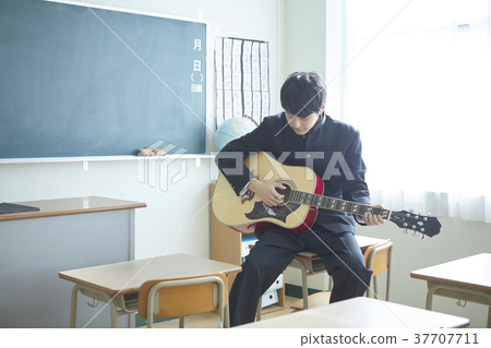 Male student playing guitar in the classroom 37707711