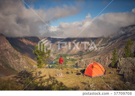Person stands near the camping and look at the Person stands near the camping and look at the 37709708