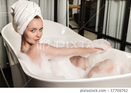 Woman Taking A Bubble Bath At Her Home