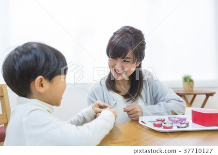 Mother giving chocolate to son 37710127