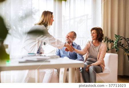 Female doctor talking to a senior couple. Female doctor talking to a senior couple. 37711023