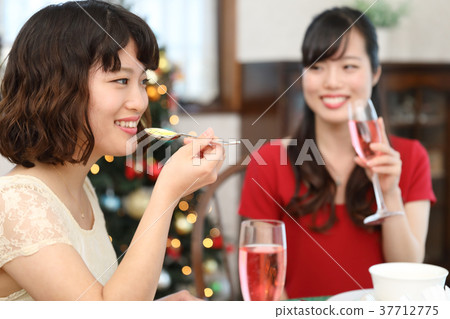 Two young women eating Christmas 37712775