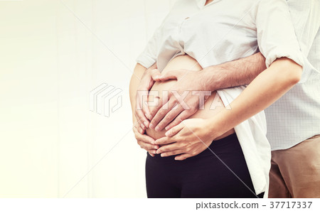 Cluse Up Pregnant Woman and Husband Hugging Tummy 37717337