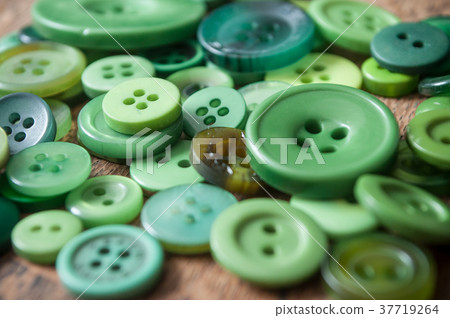 green sewing buttons on wooden background green sewing buttons on wooden background 37719264
