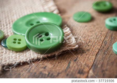 green sewing buttons on wooden background 37719306