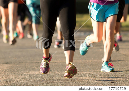 Runners legs at a 5K on a dirt psth 37719729