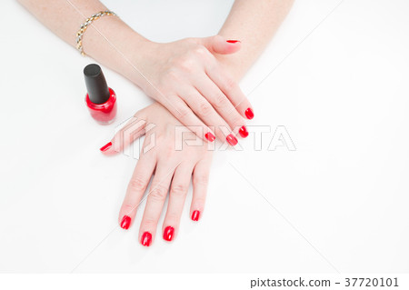Female hands with manicure and red lacquer on a Female hands with manicure and red lacquer on a 37720101