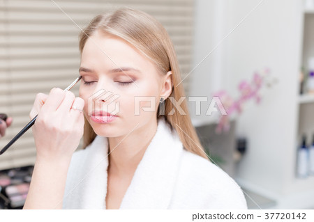 Paint eyes. Makeup artist creating beautiful 37720142