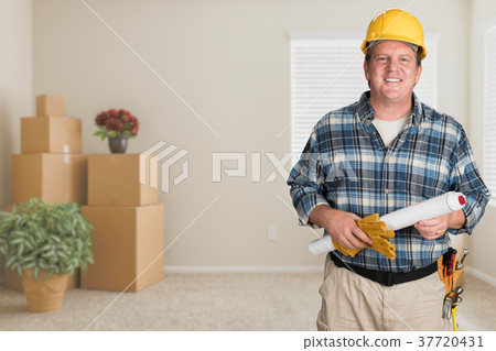 Contractor With Plans and Hard Hat Inside Empty Room with Moving Contractor With Plans and Hard Hat Inside Empty Room with Moving 37720431
