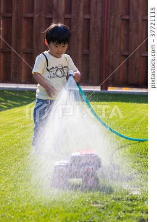 使用用水的男孩在庭院裡 37721118