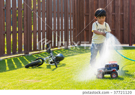 使用用水的男孩在庭院裡 37721120