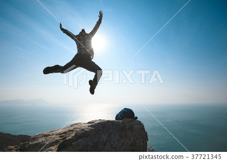 free hiker jumping on sunrise seaside cliff edge free hiker jumping on sunrise seaside cliff edge 37721345