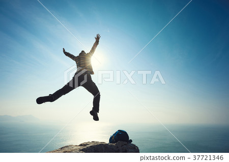 free hiker jumping on sunrise seaside cliff edge free hiker jumping on sunrise seaside cliff edge 37721346