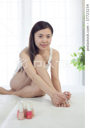 A woman painting a pedicure A woman painting a pedicure 37723234