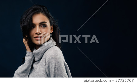 Young smiling woman wearing gray sweater Young smiling woman wearing gray sweater 37725707