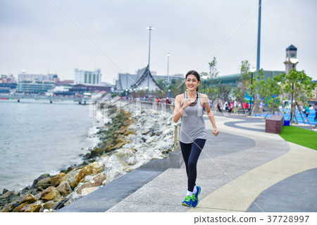 Sports concept. Beautiful girl is exercising on the beach with r 37728997