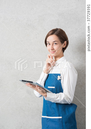 Woman with tablet PC in apron figure Woman with tablet PC in apron figure 37729391