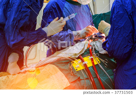 Surgeon hands are tying a knot during open heart 37731503