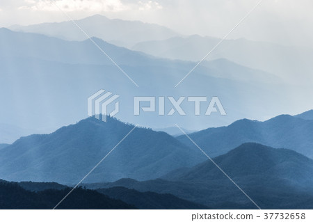 Scenic mountains range covered by soft fog Scenic mountains range covered by soft fog 37732658