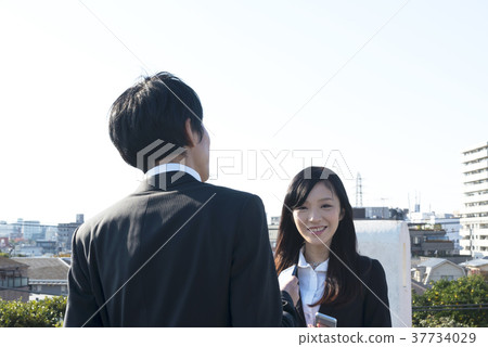 談話的女商人和的商人站立在東京後面 談話的女商人和的商人站立在東京後面 37734029