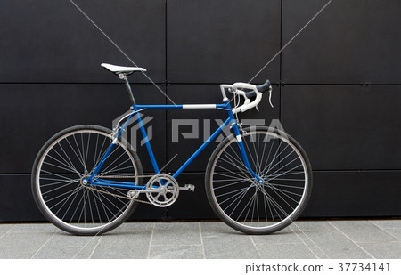 Vintage blue city bicycle against a black wall 37734141