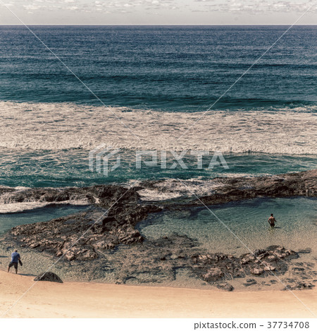 the beach near the rocks in the wave of ocean the beach near the rocks in the wave of ocean 37734708