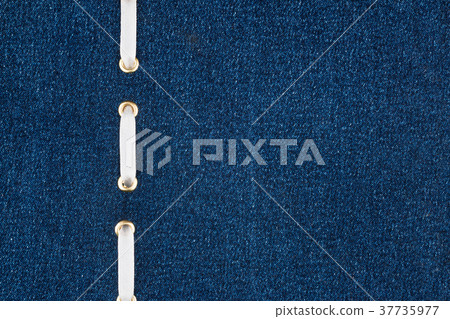 White satin ribbon is inserted in a denim fabric. White satin ribbon is inserted in a denim fabric. 37735977