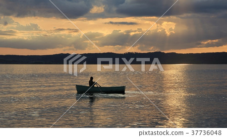 Man rowing in a small boat. Man rowing in a small boat. 37736048