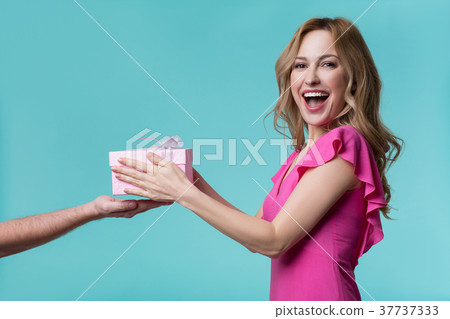 Happy girl receiving present box in male hand 37737333