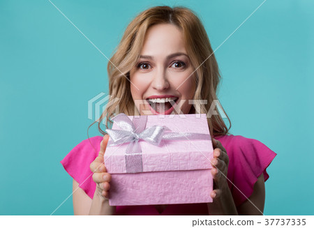 Cheerful woman is excited about present Cheerful woman is excited about present 37737335