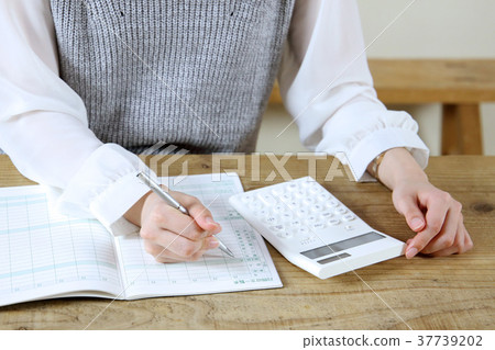A woman holding a household account book A woman holding a household account book 37739202