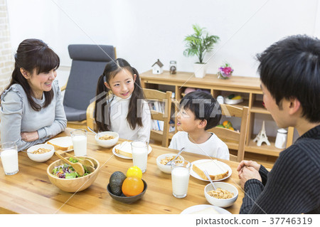 Family surrounding a breakfast table 37746319