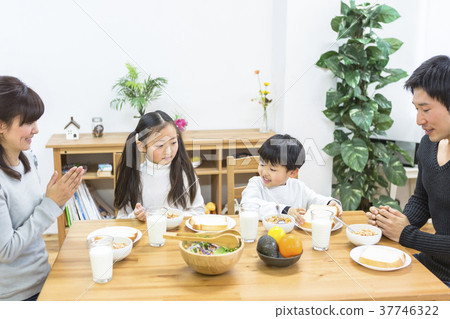 Family surrounding a breakfast table 37746322